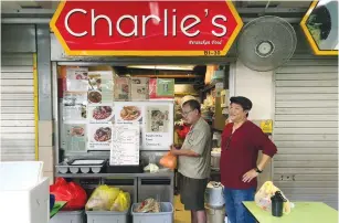  ?? (David Pierson/Los Angeles Times/TNS) ?? CHARLIE TAN (left) is one of only a handful of hawkers in Singapore cooking Peranakan food, a meticulous cuisine influenced by centuries of Chinese and Malay intermarri­age. K.F. Seetoh (right), a street food guide publisher, has championed hawker culture.