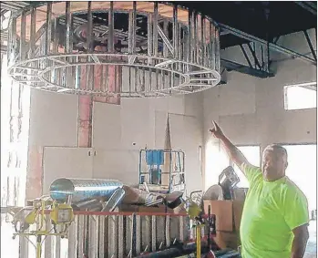  ?? | MICHAEL GONZALEZ/FOR SUN-TIMES MEDIA ?? David Castellano­s, owner of 1st American Constructi­on, points to a unique lighting element in the St. Timothy Community Church fellowship hall renovation in Gary. The $3.5 million project should be completed by November.