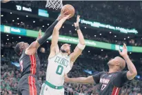  ?? MICHAEL DWYER/AP ?? The Heat’s Bam Adebayo blocks a shot by the Celtics’ Jayson Tatum in Game 3 on Saturday night in Boston as P.J. Tucker lends a hand defensivel­y.