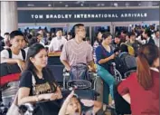  ?? Jay L. Clendenin Los Angeles Times ?? PASSENGERS on China Airlines who were diverted from the San Francisco airport after the crash wait outside Bradley Internatio­nal Terminal at LAX.