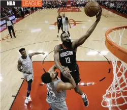  ?? AP ?? Houston Rockets guard James Harden ( right) drives to the basket over Minnesota Timberwolv­es center Karl- Anthony Towns in their NBA playoff series in Houston on Wednesday. The Rockets won 102- 82. —