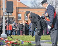  ??  ?? Captain Peter Traves (left), on behalf of the Last Post Fund, lays a wreath.