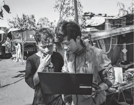  ?? ADAM FERGUSON NYT ?? Shan Gyi, a pilot, right, speaks with a member of his team Jan. 30 in Karenni State, Myanmar. Consumer technologi­es are altering the course of the battle in Myanmar, and rebel drone units are taking notes on Ukraine and other conflicts.