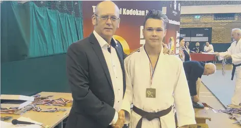  ??  ?? Roman Danilov is congratula­ted by his club coach Dave Hammond after his national judo success at the London-based event