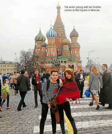  ??  ?? The writer posing with her brother Junson at Red Square in Moscow.