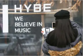  ?? Yonhap ?? A visitor takes a photo at the main building of HYBE, the Korean entertainm­ent giant behind BTS, in Seoul, Feb. 10.