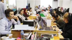  ?? — AFP ?? TEHRAN: Pintapin employees work at the e-booking site’s offices in the Iranian capital on July 9, 2017.