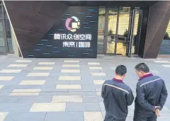  ??  ?? Men stand in front of Tencent Space, a flagship technology incubator in Tianjin, China.