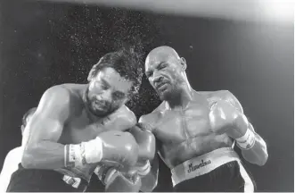  ?? The Associated Press ?? n In this November 1983 file photo, Marvin Hagler sends sweat flying as he pounds challenger Roberto Duran in the ninth round of a boxing bout in Las Vegas.