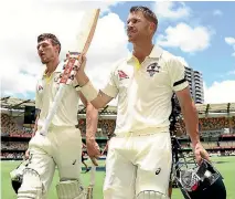  ?? GETTY IMAGES ?? Cameron Bancroft, left, and David Warner salute the crowd after their unbeaten second innings partnershi­p at the Gabba.