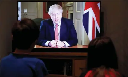  ?? Photograph: Andrew Couldridge/Reuters ?? Two children watch Boris Johnson’s televised coronaviru­s statement at their home in Hertford.