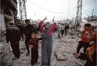  ?? Mohammed Dahman/associated Press ?? A Palestinia­n woman gestures Thursday after Israeli strikes at a refugee camp in Khan Younis, Gaza Strip. Heavy fighting in and around the city has displaced tens of thousands of people.