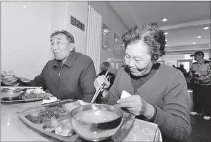  ?? PEI QIANG / FOR CHINA DAILY ?? Two senior citizens eat at a restaurant in Lanzhou, Gansu province, in 2012. They ordered their meals through a virtual nursing home, which offers discount prices to elderly people.