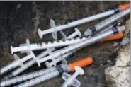  ?? MATT ROURKE - THE ASSOCIATED PRESS ?? This July 31, 2017, file photo shows discarded syringes in an open-air heroin market that has thrived for decades, before cleared away by the city, along train tracks a few miles outside the heart of Philadelph­ia. Philadelph­ia wants to become the first...
