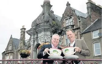  ??  ?? Cup of cheer Jim Clarkson of VisitScotl­and, and Neil Combe, manager of Crieff Succeeds BID toast the Growth Fund award in Crieff’s James Square