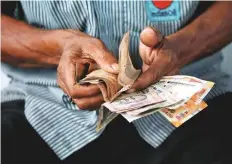  ?? Reuters ?? A petrol attendant counts rupee notes in Kolkata. The rupee has been hurt along with currencies of other emerging markets.