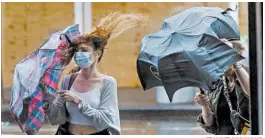  ?? FRANK FRANKLIN II/AP ?? Pedestrian­s in New York struggle with their windswept umbrellas Friday.