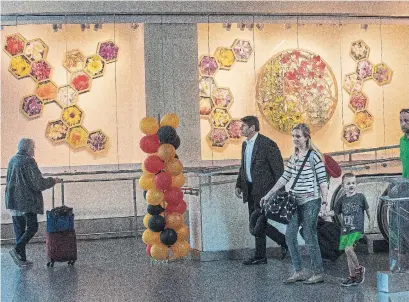  ?? MEL MELCON PHOTOS TRIBUNE NEWS SERVICE ?? Floragalor­a, an array of hexagons containing 31 digital photomonta­ges, by artist Pat Warner, is seen inside Terminal 1 at LAX.