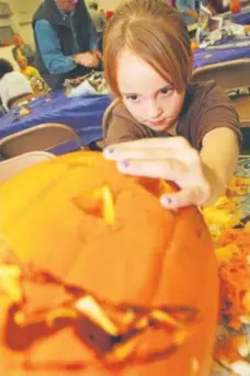  ?? Vance Green, Idaho Press Tribune ?? A child scrapes the insides out of her jack-o’-lantern in Caldwell, Idaho.