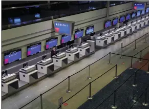  ?? (AP/John Locher) ?? A lone person works April 21 at the Delta Air Lines check-in desk at McCarran Internatio­nal Airport in Las Vegas. The company’s passenger counts fell by 93% in the second quarter.