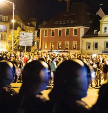  ?? Foto: dpa/Christian Essler ?? Polizisten und rechte Demonstran­ten in Bautzen vor einem Jahr auf dem Kornmarkt