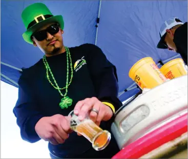  ?? RECORDER FILE PHOTO BY CHIEKO HARA ?? Angel Campos, of Valley Cab, serves a glass of beer at the 2016 Portervill­e Breakfast Lions Club Brewfest at the Veterans Memorial Building in Portervill­e. Between 600 and 1,000 people are expected to attend this year's St. Patrick's Day Brewfest,...