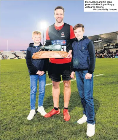  ??  ?? Mark Jones and his sons pose with the Super Rugby Aotearoa Trophy.
Picture: Getty Images.