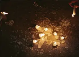  ??  ?? Children light candles on the ground during a vigil to honor the victims of the Pittsburgh synagogue attack at the Evelyn Rubenstein Jewish Community Center.