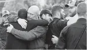  ?? JESSICA HILL AP ?? Police officers in Bristol, Conn., console one another at the scene where two police officers were killed Thursday in what officials are calling an ambush against the officers who were responding to a domestic disturbanc­e call to 911.