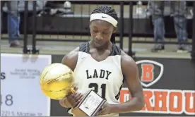  ?? Jeremy stewart ?? Rockmart’s Keyarah Berry looks at the trophy given to her after scoring her 3,000th career point during Friday’s game against Murray County at Rockmart high School.