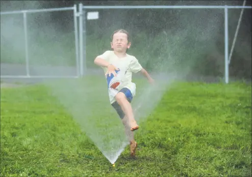  ?? Erik Trautmann / Hearst Connecticu­t Media ?? Five-year old Jamie Shantz runs through a sprinkler as part of the Ridgefield Parks and Recreation Fun Camp at Governors Park in Ridgefield. The camp runs June through August until school begins. The camp is open to drop-ins and out-of-town residents for one day or the entire week.