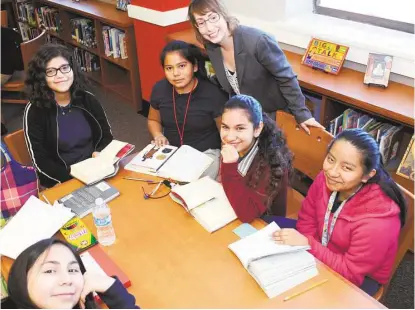  ?? George Wong / For the Chronicle ?? James Hogg Middle School librarian Mary Chance, center, talks with pupils Elizabeth Cervantes, bottom, left, Victoria Tavira, Alexya Colunga, Julianna Rangeo and Barbara Anlceto, inside the renovated library at the school, 1100 Merrill.