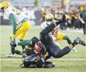  ?? MARK BLINCH/THE CANADIAN PRESS ?? Tiger-Cats running back Alex Green scores a touchdown against the Edmonton Eskimos in Hamilton’s come-from-behind 25-24 home win Thursday at Tim Horton’s Field.