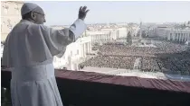  ??  ?? Pope Francis waves to about 50,000 faithful while delivering the traditiona­l Christmas Day blessing from the main balcony of St. Peter’s Basilica at the Vatican.