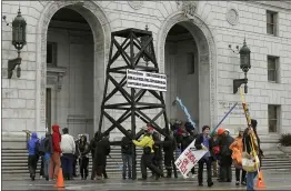  ?? JEFF CHIU — THE ASSOCIATED PRESS FILE ?? Protesters prepare to take down a makeshift oil derrick that was set up in front of the California State Office Building in San Francisco to protest fracking.