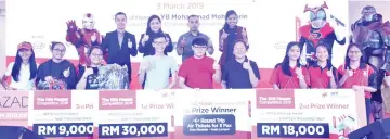  ??  ?? Group photo of the top three winners of the GIG Master 2019 Competitio­n, along with their mock cheques and prizes, flanked by cosplayers and representa­tives from INTI and Lazada and (fourth from left) Mohammad.