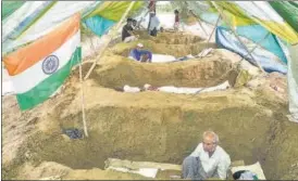  ?? PTI ?? Farmers rest in pits during a protest against three central farm laws and compensati­on for their land acquired under the UPHDB’s Mandola housing scheme in Ghaziabad on Sunday,