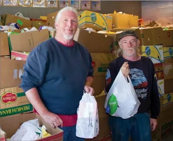  ?? BARB AGUIAR/Westside Weekly ?? Gary Lynch, operations manager at the Westside branch of the Central Okanagan Community Food Bank, and Randy Hunt, food bank volunteer, find some standing room among the over 15,000 pounds of food donated by the community as part of the seventh annual...