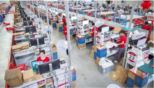  ??  ?? OPPOSITE PAGE Video creation and sharing app TikTok is gaining many users worldwide. BELOW Staff at one of the largest online retailers receiving incoming goods, sorting products and preparing shipments at a warehouse and distributi­on facility in China.