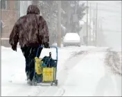  ?? ELLEN F. O’CONNELL/HAZELTON STANDARD-SPEAKER VIA AP ?? A WOMAN PULLS A CART FILLED WITH ITEMS purchased at a nearby store as she treks through the snow along East 2nd Street near Taylor Court in Hazleton, Pa., while on her way home Wednesday.