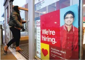  ?? AP PHOTO/STEVEN SENNE ?? A passerby walks past an employment hiring sign while entering a Target store location, in Westwood, Mass., earlier this month. The Federal Reserve says there’s evidence that hiring has picked up in recent weeks, though the job market remains badly damaged by the pandemic. In its semi-annual monetary policy report released Feb. 19, the Fed says job data compiled by payroll processor ADP indicate that employment improved modestly through early February.