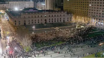  ?? — AFP photos ?? People li lit candles and mobile phones in front of La Moneda Presidenti­al Palace as women march around the building in Santiago, during a mainly-women’s demonstrat­ion to commemorat­e the 50th anniversar­y of the military coup led by General Augusto Pinochet against socialist President Salvador Allende.