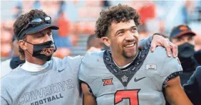  ??  ?? Coach Mike Gundy and quarterbac­k Spencer Sanders stand for Oklahoma State’s alma mater after the win last week.