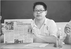  ??  ?? Dr Ting shows the newspaper report on the new requiremen­t imposed by Ministry of Health.