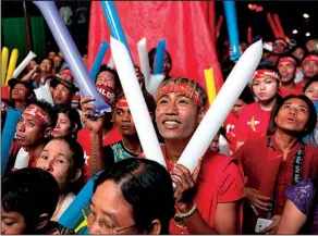  ?? AP/ KHIN MAUNG WIN ?? Supporters of Burma opposition leader Aung San Suu Kyi’s National League for Democracy party cheer as they watch the results of the general election on a screen displayed outside the party’s headquarte­rs Monday in Rangoon, Burma.