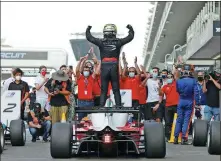  ??  ?? China’s Zhou Guanyu celebrates winning the Asian Formula 3 Championsh­ip at Abu Dhabi’s Yas Marina Circuit on Saturday. The victory means the Shanghai native needs just two more points to earn an FIA super license, which is a prerequisi­te for competing in Formula 1.