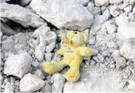  ??  ?? A toy lies in the wreckage of a building