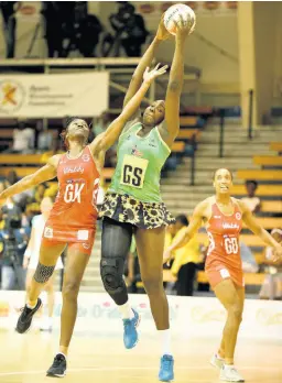  ?? FILE ?? Jamaica’s Jhaniele Fowler (centre) grabs a pass ahead of England Roses goal keeper Ama Agbeze (left) and goal defence Layla Guscoth during a netball match at the National Indoor Sports Centre in October 2018.