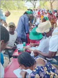  ?? ?? FROM LEFT: Smallholde­r farmers display a range of small and large grains, while others are registerin­g for the agroecolog­y seed fair in Mbire, Mashonalan­d Central province