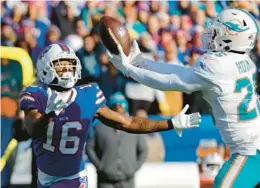  ?? JEFFREY T. BARNES/AP ?? Dolphins cornerback Xavien Howard, right, intercepts a pass intended for the Bills’ John Brown during an AFC wild-card game Jan. 15 in Orchard Park, N.Y.